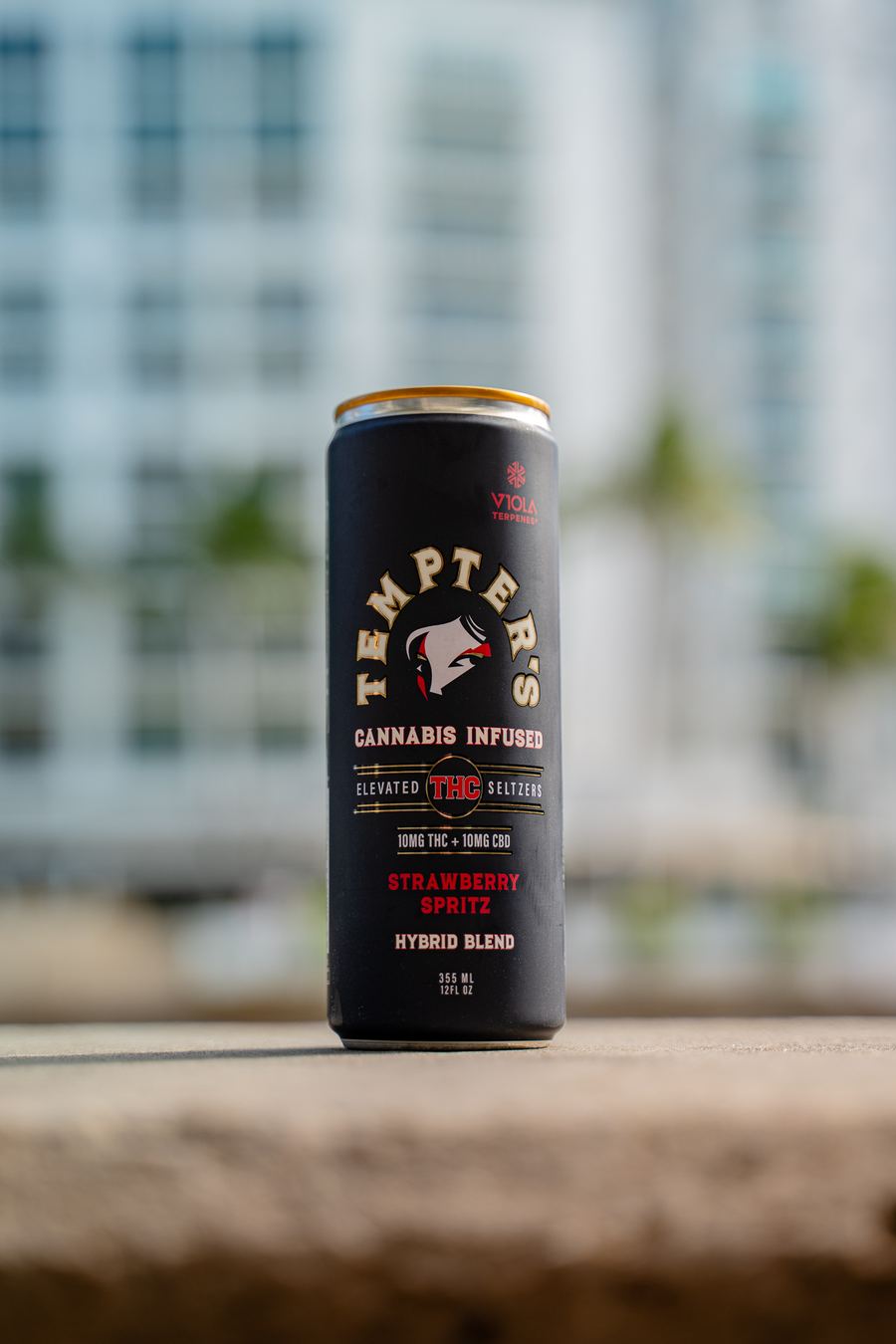 Frame: matte-black seltzer can against city bokeh
